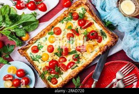 Deliciously simple tomato tart made with puff pastry, red and yellow cherry tomatoes, spinach and ricotta cheese. The perfect appetizer for summer. Co Stock Photo