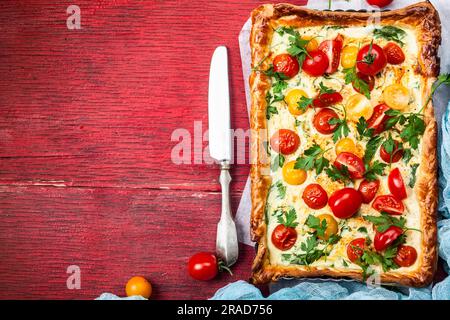 Deliciously simple tomato tart made with puff pastry, red and yellow cherry tomatoes, spinach and ricotta cheese. The perfect appetizer for summer. Co Stock Photo