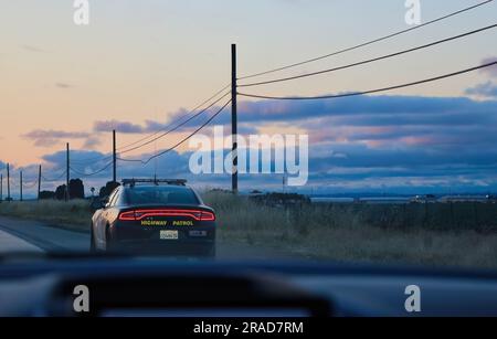 Highway patrol Dodge Charger police car pulling over a Ford Fiesta on the I-5 North California USA Stock Photo