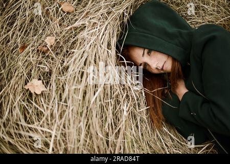 Close-up portrait of teenage girl with red head lying on grassy Stock Photo