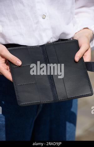 Senior woman holding an empty purse and a ten Euro banknote in her ...