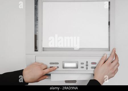 The hands of a young woman is placing a piece of paper on a flatbed scanner in preparation for copying it Stock Photo