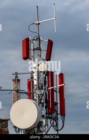 cluster of radio and tv communications antennas on a high vantage point in croatia, cellular and microwaves communications equipment with dish. Stock Photo