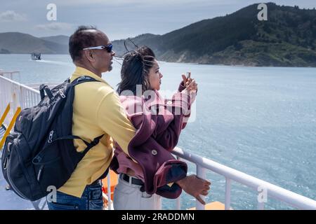 Couple enjoy amazing views on Queen Charlotte Sound on Wellington to Picton Cook Strait Ferry Crossing from North Island to South Island, New Zealand Stock Photo