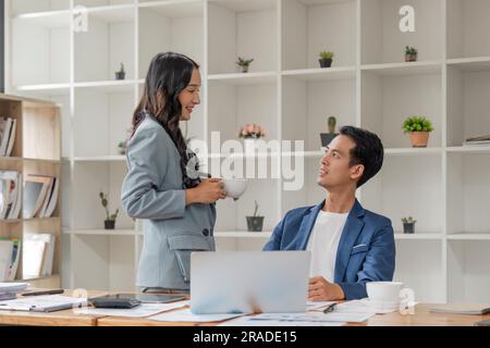 Two business people talk project strategy at office meeting room. Businessman discuss project planning with colleague at workplace while having Stock Photo