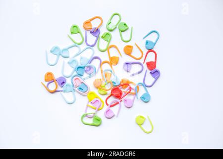 Many colorful plastic knitting markers on a white background. Stock Photo