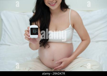 pregnant woman holding glucose meter with result of measurement sugar level. gestational diabetes concept Stock Photo