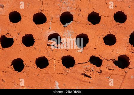 Building material red brick with holes. Solid clay bricks used for construction. Concept of repair and building materials. Stock Photo