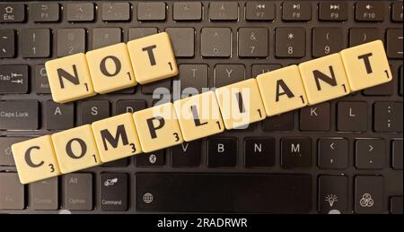 Not Compliant in Scrabble letters on a computer keyboard Stock Photo