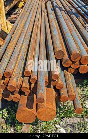 Round steel billet for rolling metal pipes in warehouse of finished metal products Stock Photo