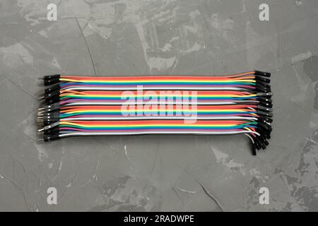 Male to female jumper cable for Arduino. Set of colored connecting wires on gray background. Wires for connecting modules and sensors for reliable con Stock Photo