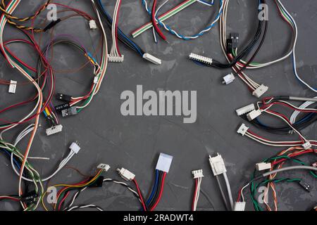 Colored cables and wires with connectors on gray concrete background. colorful different computer and other wires. Telecommunications. Blank for postc Stock Photo