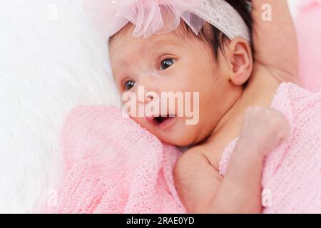 happy newborn baby girl in blanket on a bed Stock Photo