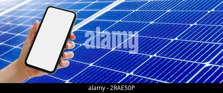Smart phone with blank screen in hand on background of blue solar panel. Stock Photo