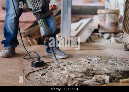 labor using a jackhammer to break up a concrete floor Stock Photo - Alamy