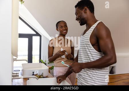 Happy african american couple brushing teeth in bathroom Stock Photo