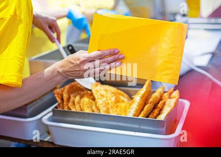 pack a delicious hot cheburek in edible yellow paper. Street food, food to go Stock Photo