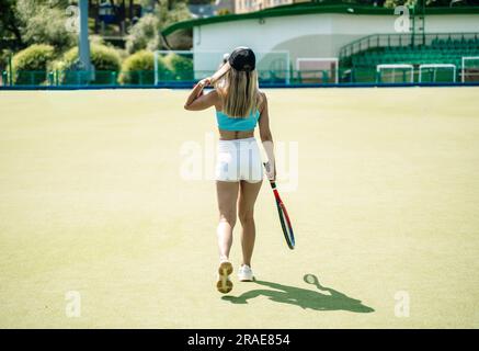Tennis player woman on sport court in summer. Female sport, athlete body, healthy lifestyle concept. High quality photo Stock Photo