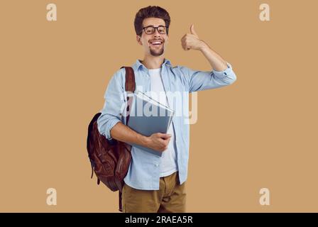 Happy man student with backpack showing thumbs up Stock Photo