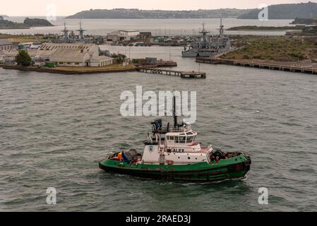 Cobh, Ireland, EU.  9 June 2023.  Alex an escort tug underway on Cobh Harbour with a background of Haulbowline Island and the naval. service base. Stock Photo