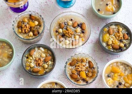 Traditional Turkish Dessert Ashure  or Noah's Puding in many bowls designed on decorative surface.Top view Stock Photo