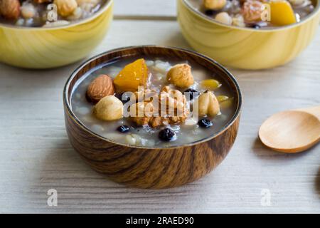 Traditional Turkish Dessert Ashure,or Noah's Puding designed in bamboo bowls on wooden surface Stock Photo