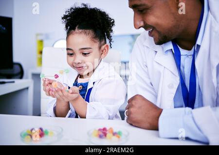 Science, research and child with her father in the lab working on an experiment or test with sweets. Biology, candy and girl kid student doing project Stock Photo