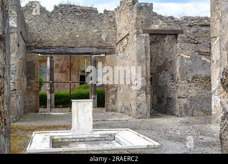 House in Pompeii near Naples, Italy. Pompeii is ancient Roman city died from eruption of Vesuvius. Courtyard of rich house in Pompeii in summer. Ruins Stock Photo