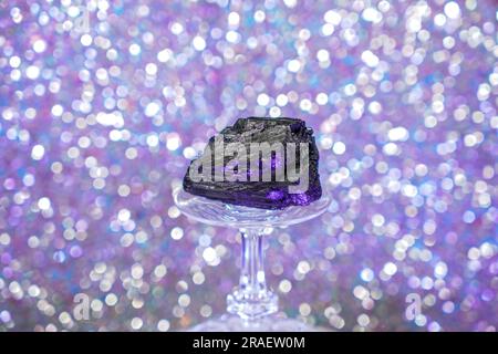 Tourmaline in the studio against a blue background on a crystal glass Stock Photo