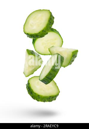 Slices of green cucumbers on a white isolated background. Slices of green cucumbers scatter in different directions. The concept of a delicious Stock Photo