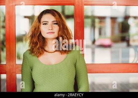 Outdoor portrait of beautiful young girl, wearing green top, golden necklace Stock Photo