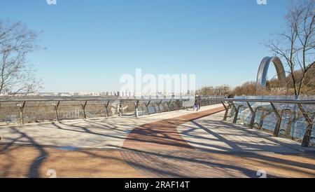 Kyiv, Ucraine-03.30.2023: Pedestrian and bicycle bridge across Saint Volodymyr descent in Kyiv, Ukraine. Glass Bridge, modern footbridge connecting hi Stock Photo