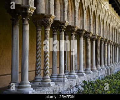 Arab Norman style arches and columns with Romanesque style carved chapiters on the exterior of the Benedictine cloister of Monreale in Sicily, Italy. Stock Photo