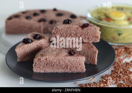 Slices of Navara rice vattayappam. Steamed rice cake made with a fermented batter of navara rice and coconut and steamed in a round dish served with k Stock Photo