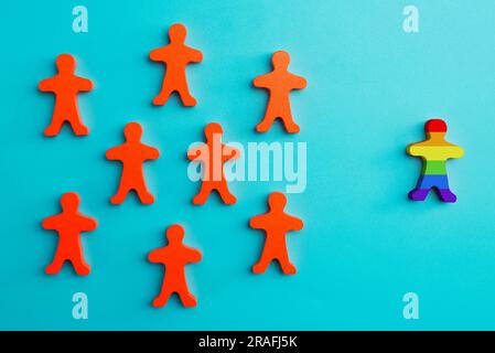 A lot of red figurines and one colored figurine as symbol of diversity Stock Photo