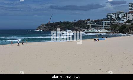 723 Tourist beachgoers on the Bondi Beach sand while surfers try to ride the waves. Sydney-Australia. Stock Photo