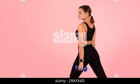 Portrait Of Motivated Young Sporty Woman Exercising With Dumbbells Stock Photo