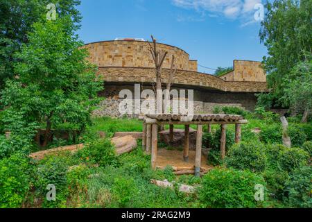 Wooden platform, log structure for animals, wooden house for the lion among the thickets. Wooden scaffolding during the restoration of an ancient ston Stock Photo