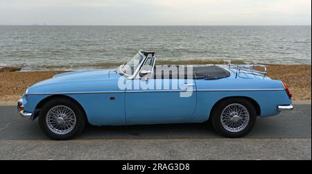 Classic  Light Blue  MG Roadster  Car  parked on seafront promenade with sea in background. Stock Photo
