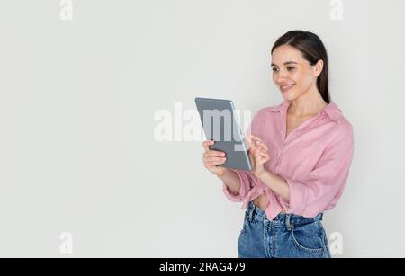 Cheerful young woman using digital tablet and smiling Stock Photo
