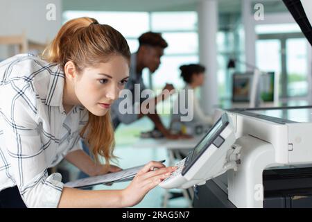 female technician is checking printer Stock Photo
