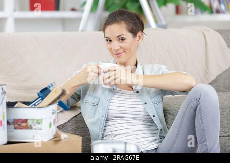 cheerful woman painting her new apartment takes a break Stock Photo