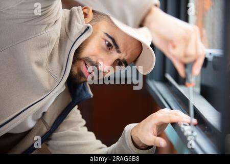 worker fasten the handle to a plastic window Stock Photo