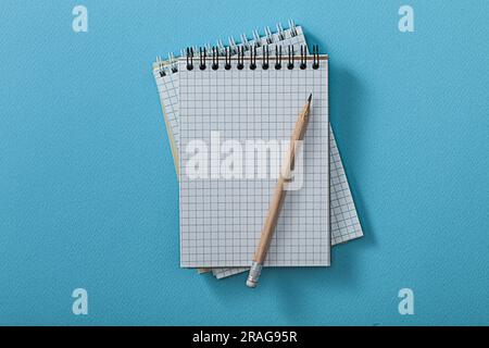 Opened Notepads With Pencil On Blue Background Stock Photo