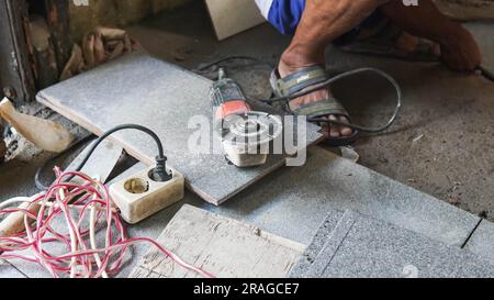Flat ceiling cutter with an electric cutter. Flat ceiling cutter with an electric cutter. worker cutting ceiling with an angle grinder in the construc Stock Photo