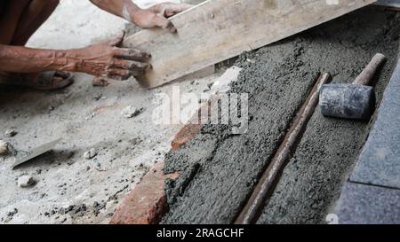 Worker or mason hands laying bricks close up. Bricklayer works at brick row. Brickwork on construction site Stock Photo