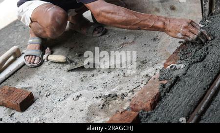 Worker or mason hands laying bricks close up. Bricklayer works at brick row. Brickwork on construction site Stock Photo