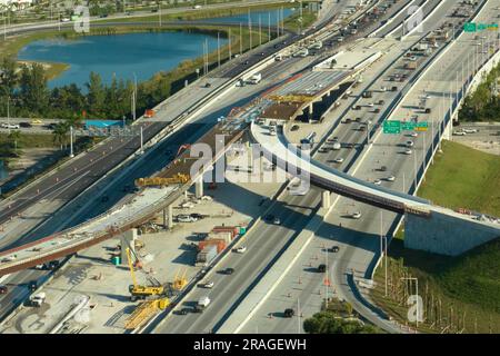 Construction roadworks on american transport infrastructure. Renovation of highway road interchange with moving traffic in Miami, Florida. Development Stock Photo