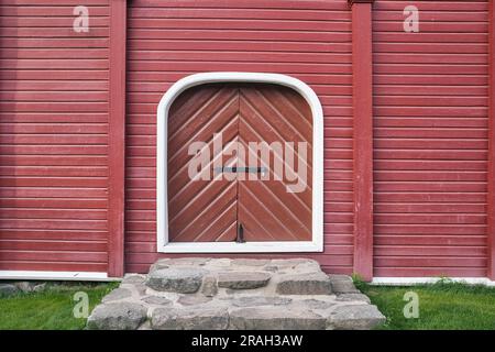 closed woorway on red painted wooden wall outdoors Stock Photo