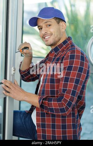 worker fasten the handle to a plastic window Stock Photo